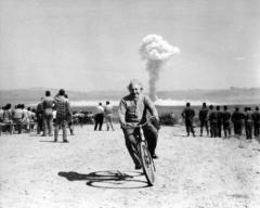 Einstein riding bike down range from nuclear bomb test